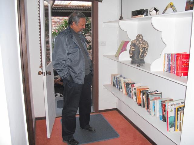 DSCF0018.jpg - Thambichayan examining the book collection at the holiday home